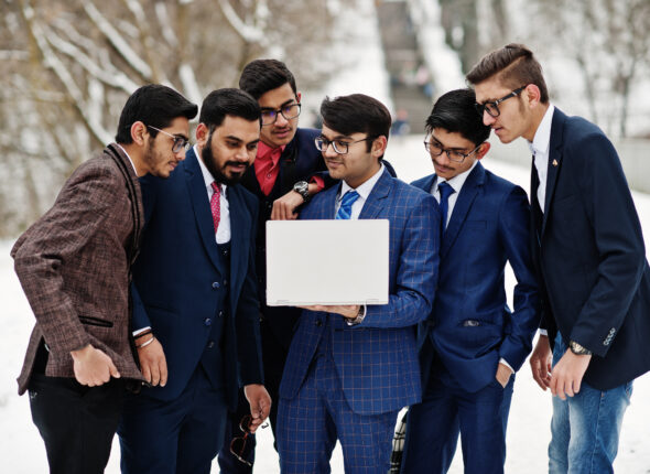 Group of six indian businessman in suits posed outdoor in winter
